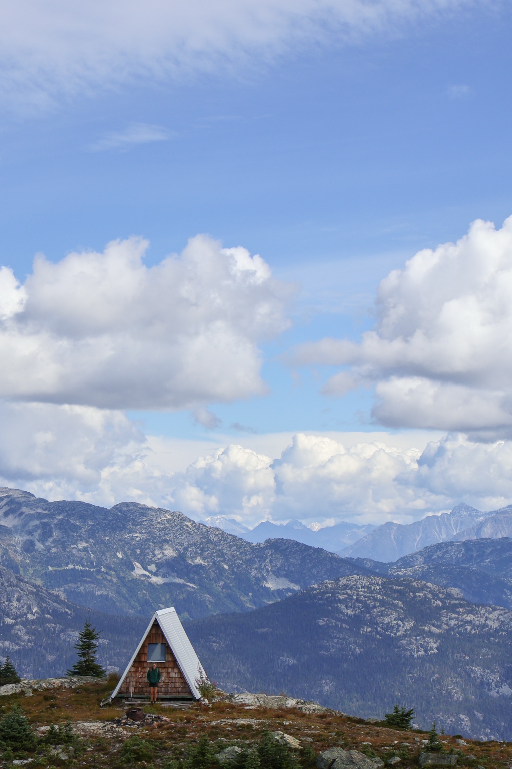 A small alpine hut beneath a wide mountain sky